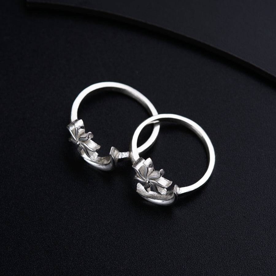 a pair of silver rings on a black surface