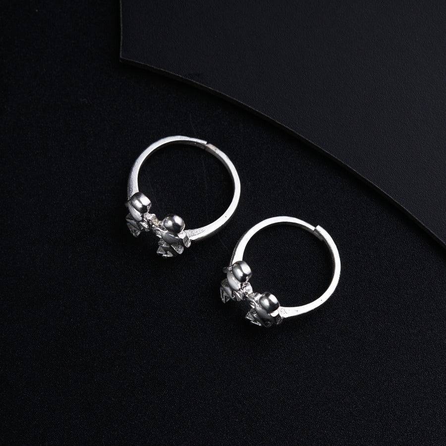 a pair of silver hoop earrings on a black background
