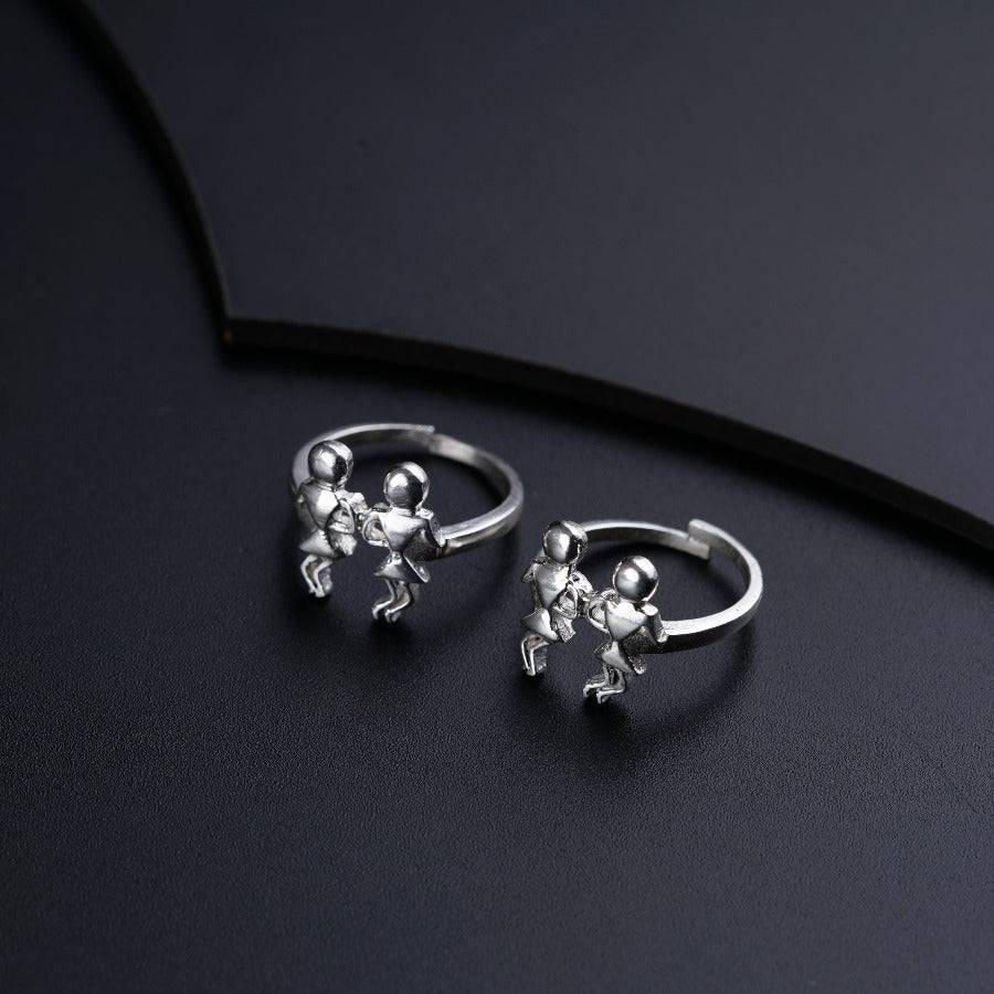 a pair of silver earrings sitting on top of a black surface