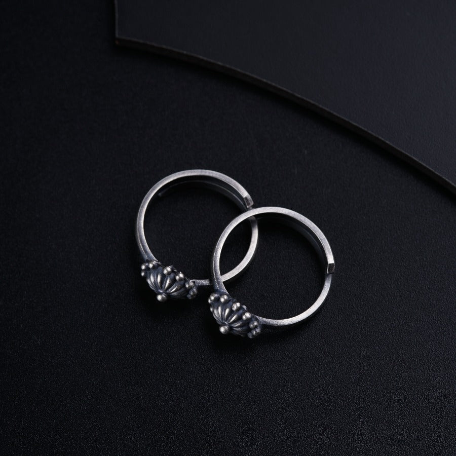 a pair of silver hoop earrings on a black surface