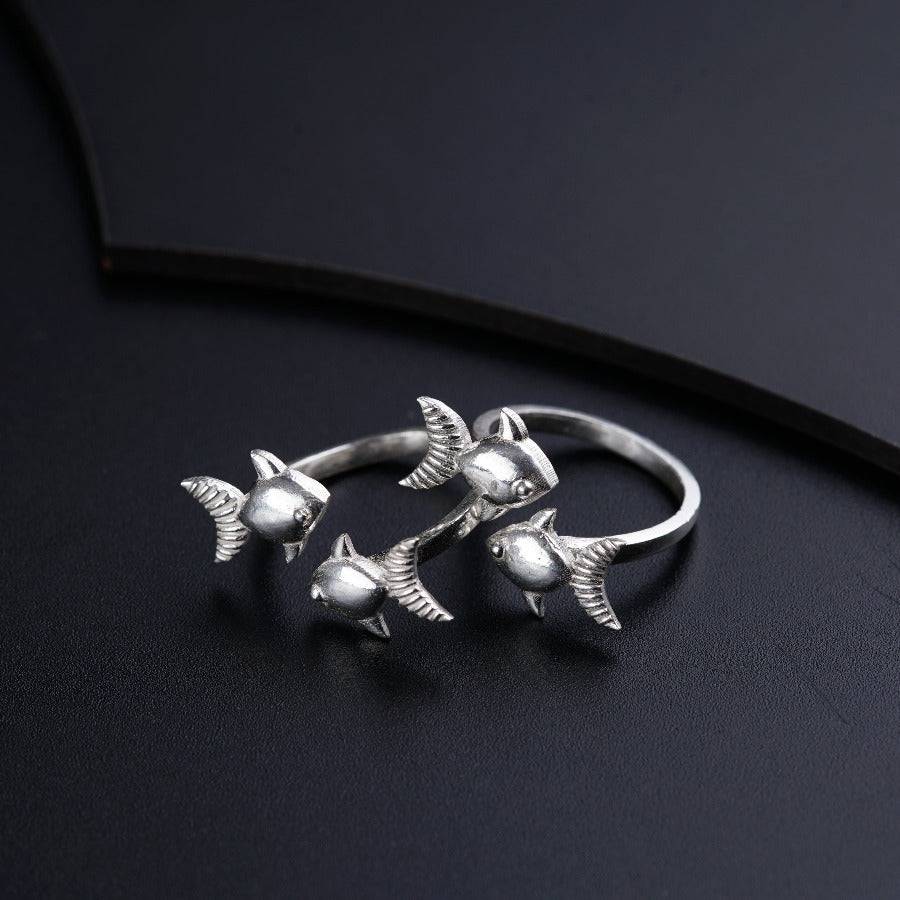 three silver birds on a black surface