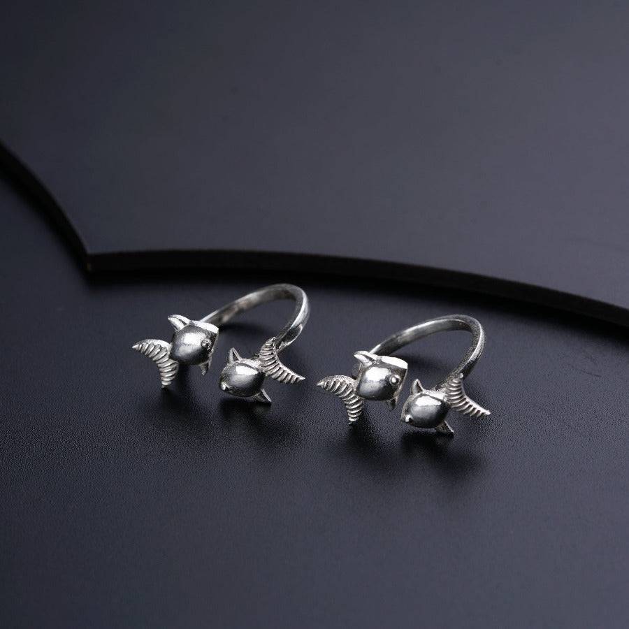 two silver birds on a black surface