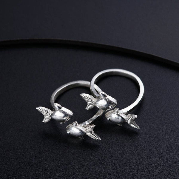 a pair of silver rings sitting on top of a black surface