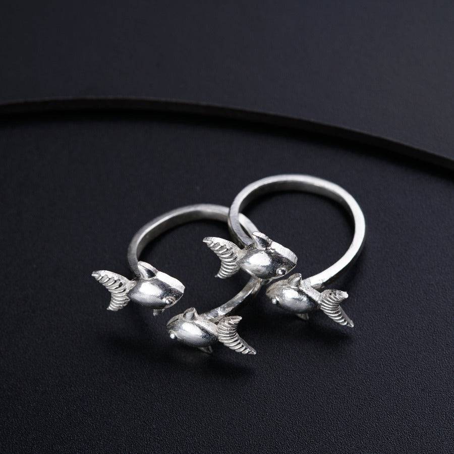 a pair of silver rings sitting on top of a black surface