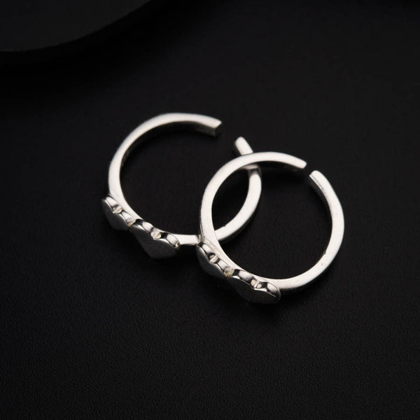 a pair of silver hoop earrings on a black surface