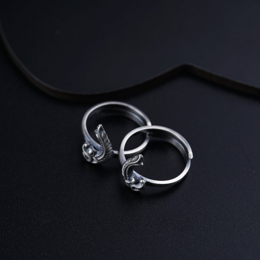 a pair of silver rings sitting on top of a black surface