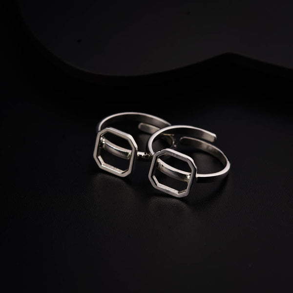 a pair of silver rings sitting on top of a black surface