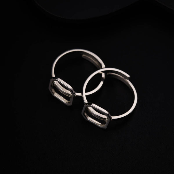 a pair of silver hoop earrings sitting on top of a black surface