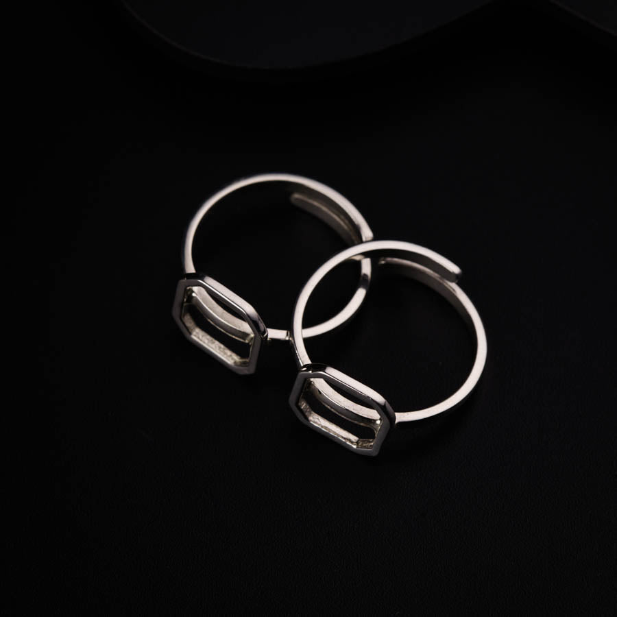 a pair of silver hoop earrings sitting on top of a black surface
