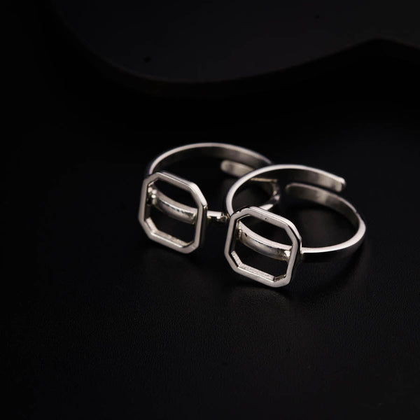a pair of silver rings sitting on top of a black surface