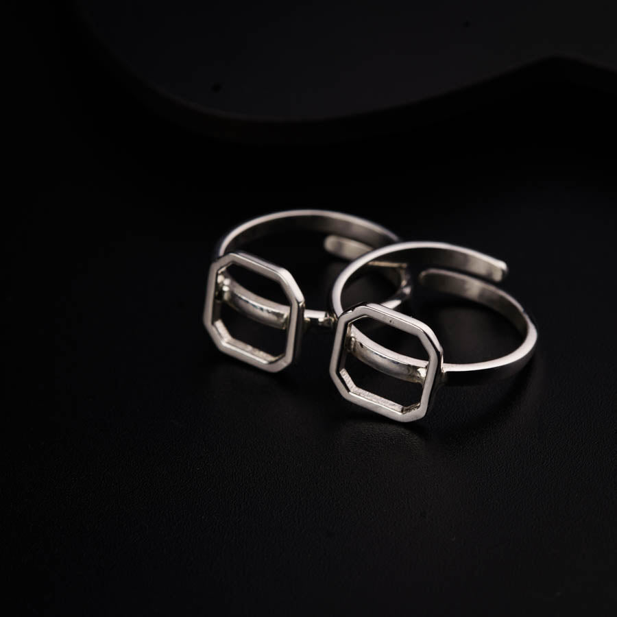 a pair of silver rings sitting on top of a black surface