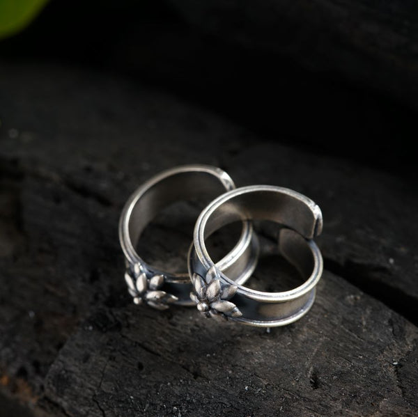two wedding rings sitting on top of a piece of wood