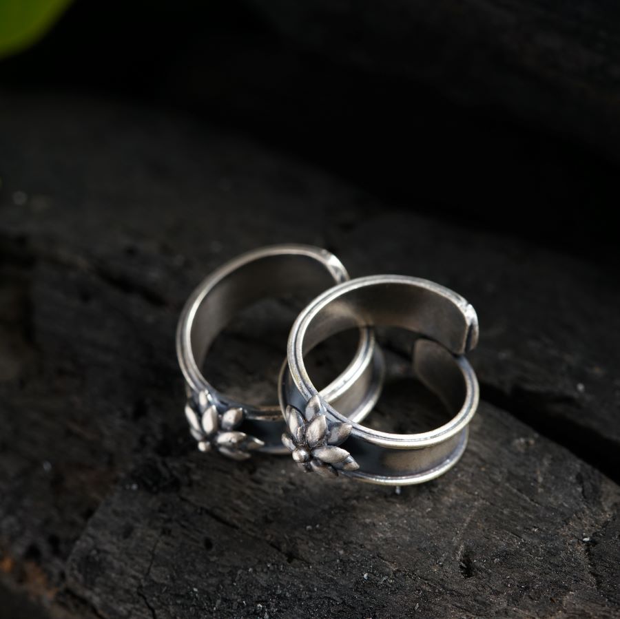 two wedding rings sitting on top of a piece of wood