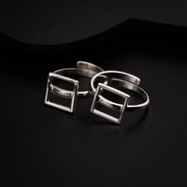 two silver rings sitting on top of a black surface