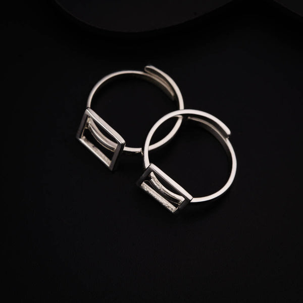a pair of silver hoop earrings sitting on top of a black surface