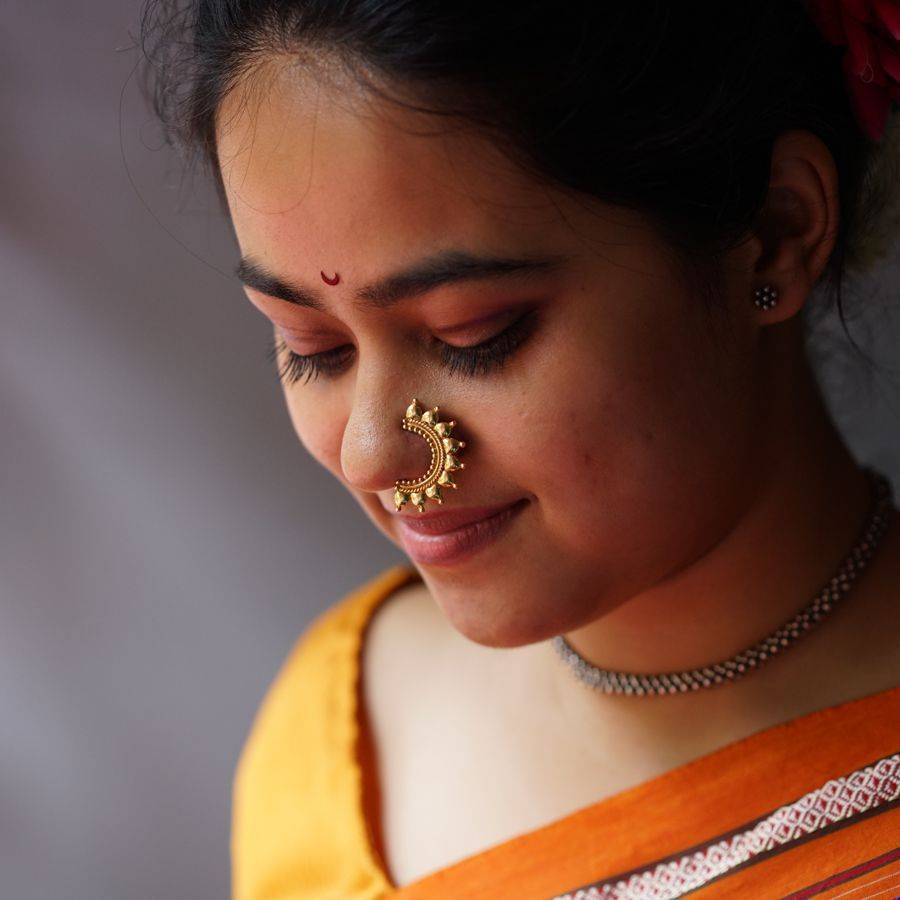 a woman wearing a nose ring with a gold nose ring