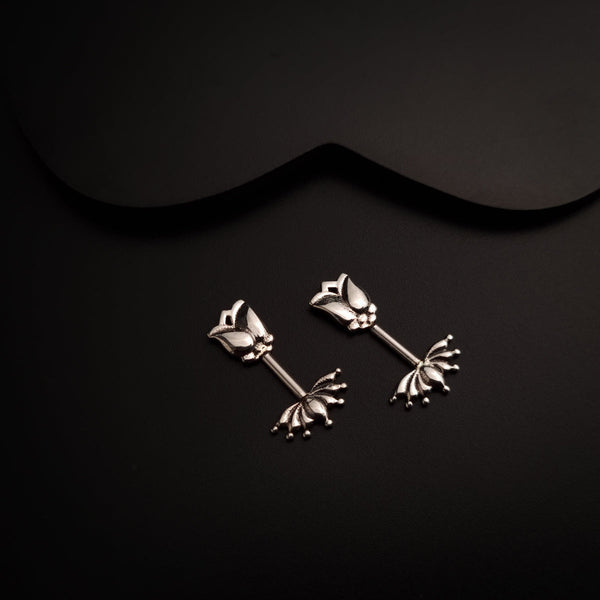 a pair of silver earrings on a black background
