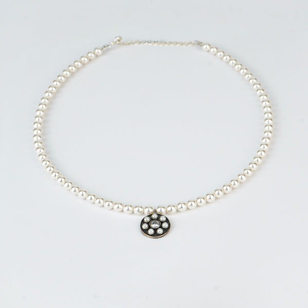 Close-up of pearl necklace with silver pendant, fine jewelry detail
