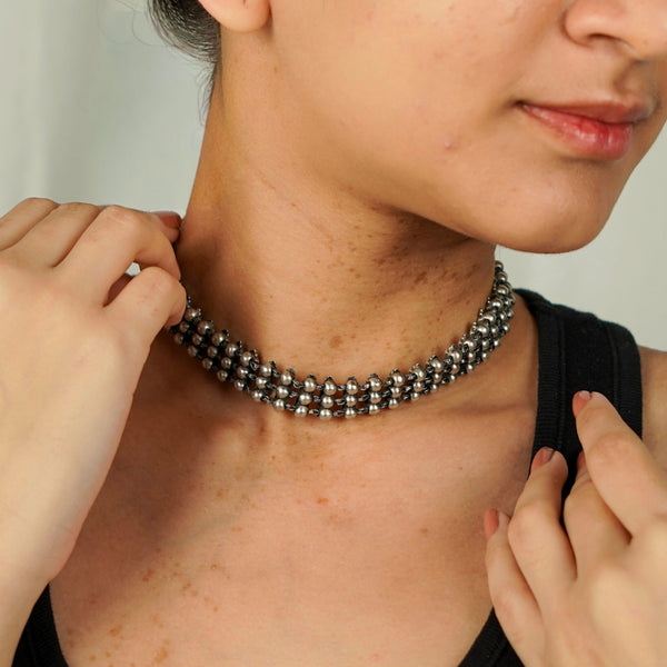 Close-up of silver oxidized two way choker necklace worn on a model, highlighting its intricate beaded pattern