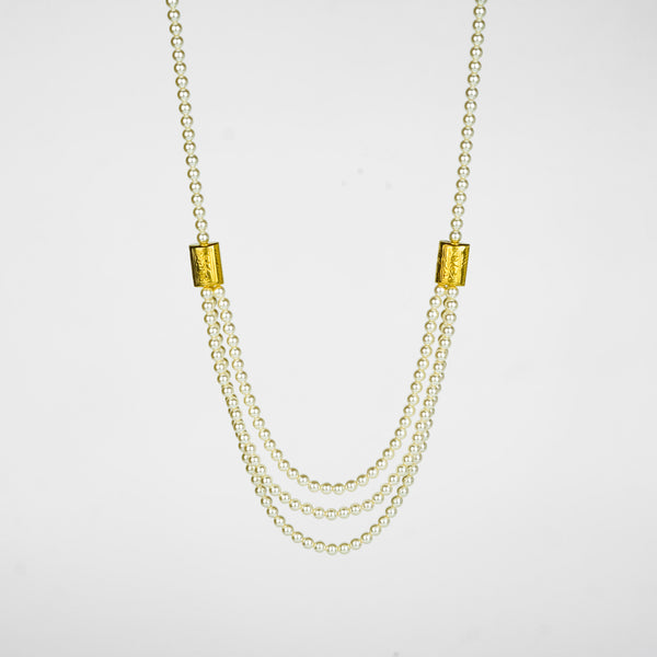 Detail shot of carved bead texture and pearl accents in necklace