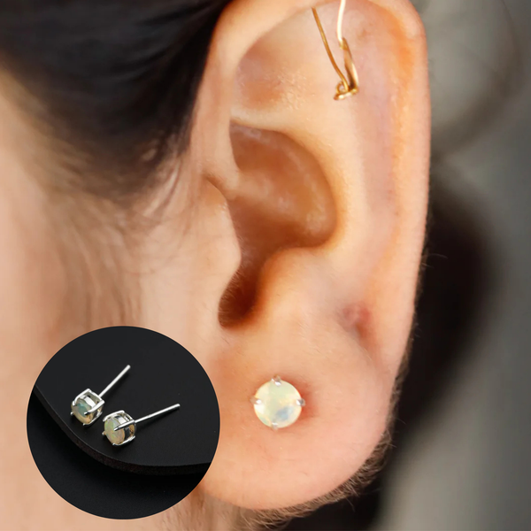 Close-up of opal earrings in ear