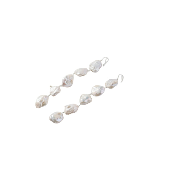 Close-up of baroque pearl earrings with silver hooks