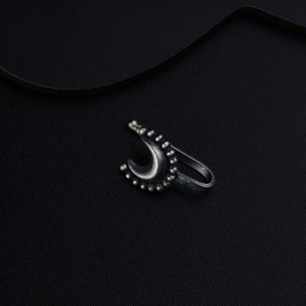 a black background with a silver ring and a pair of scissors