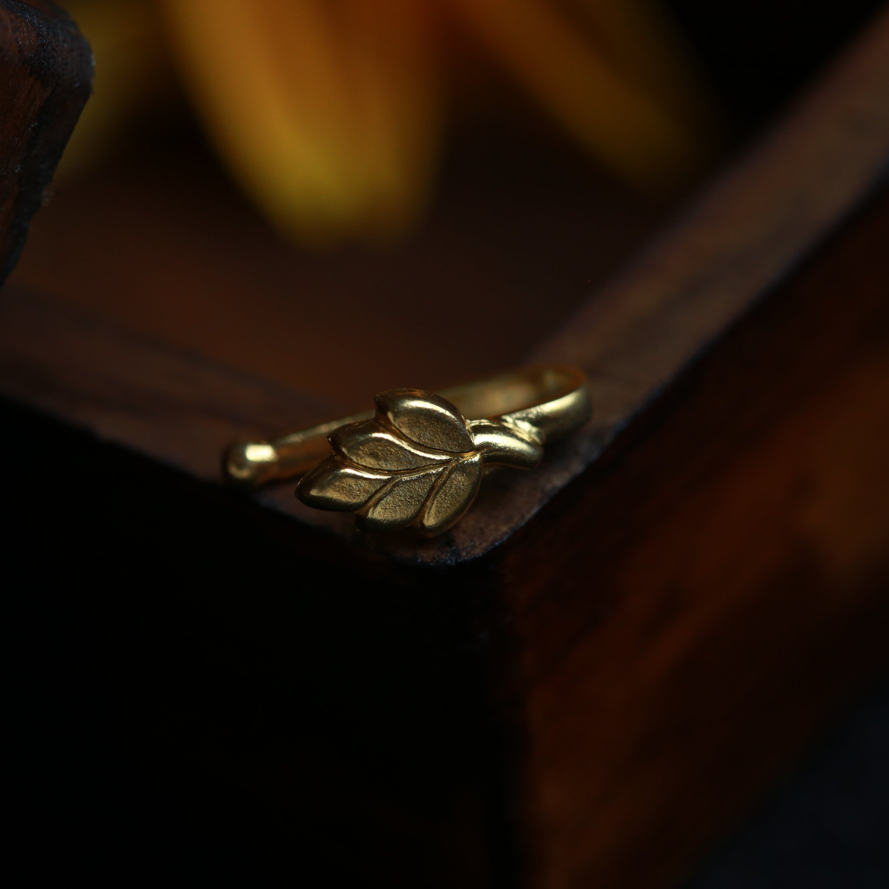 a close up of a gold ring on a wooden box
