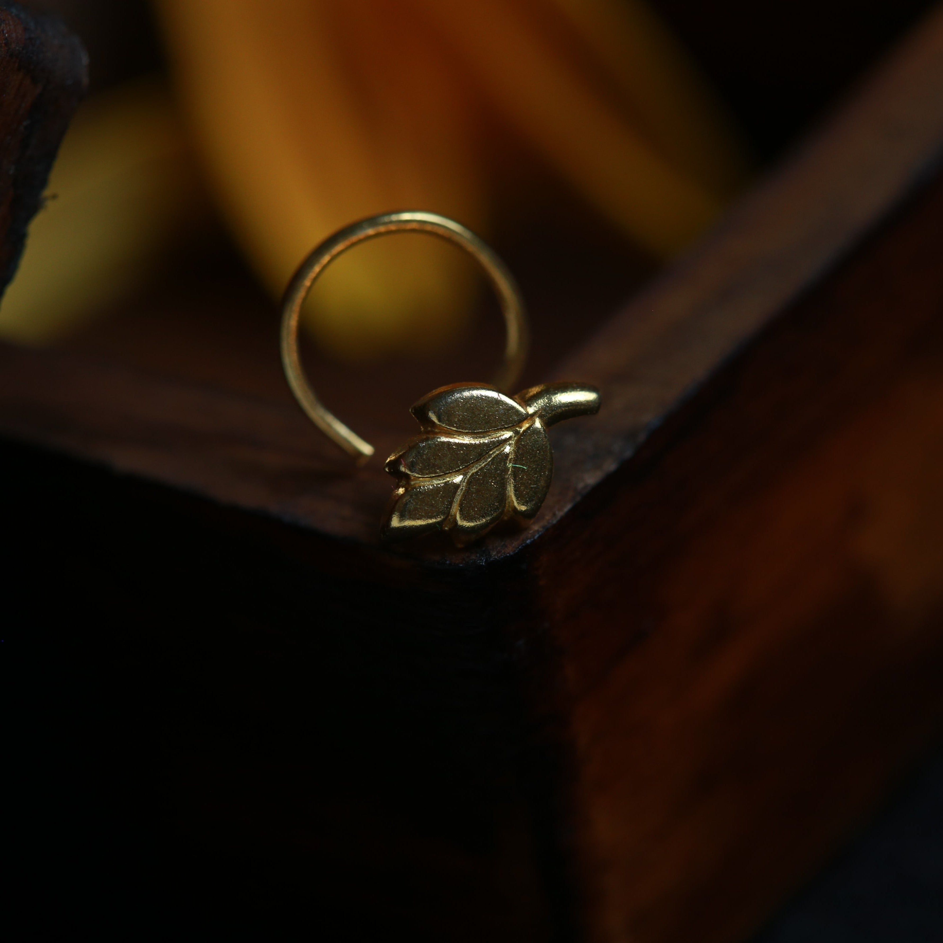 a close up of a ring with a leaf on it