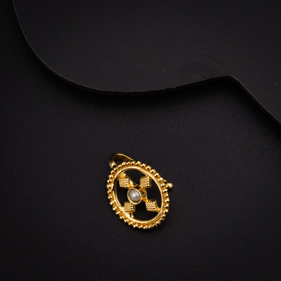 a close up of a gold brooch on a black background