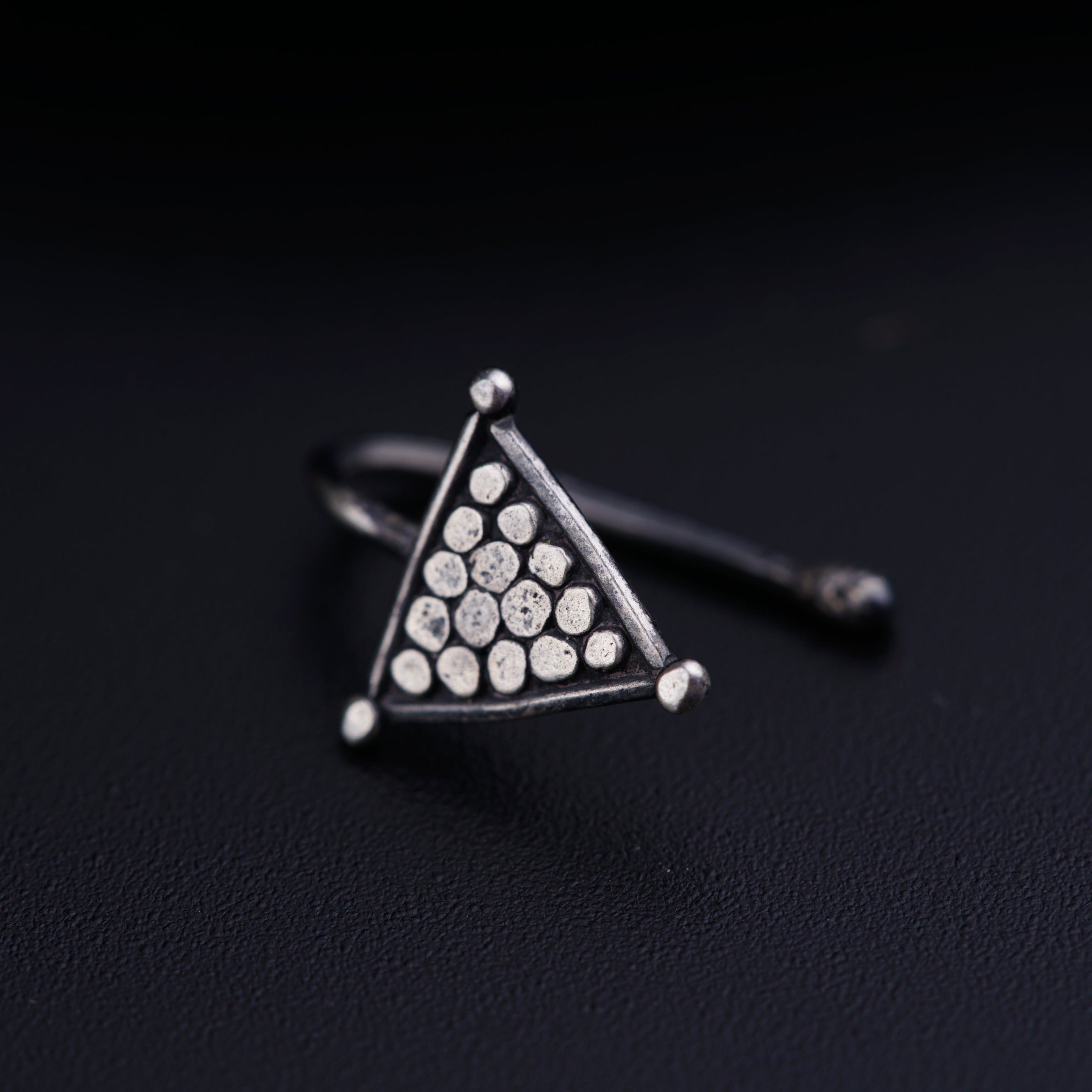 a triangle shaped ring with dots on it