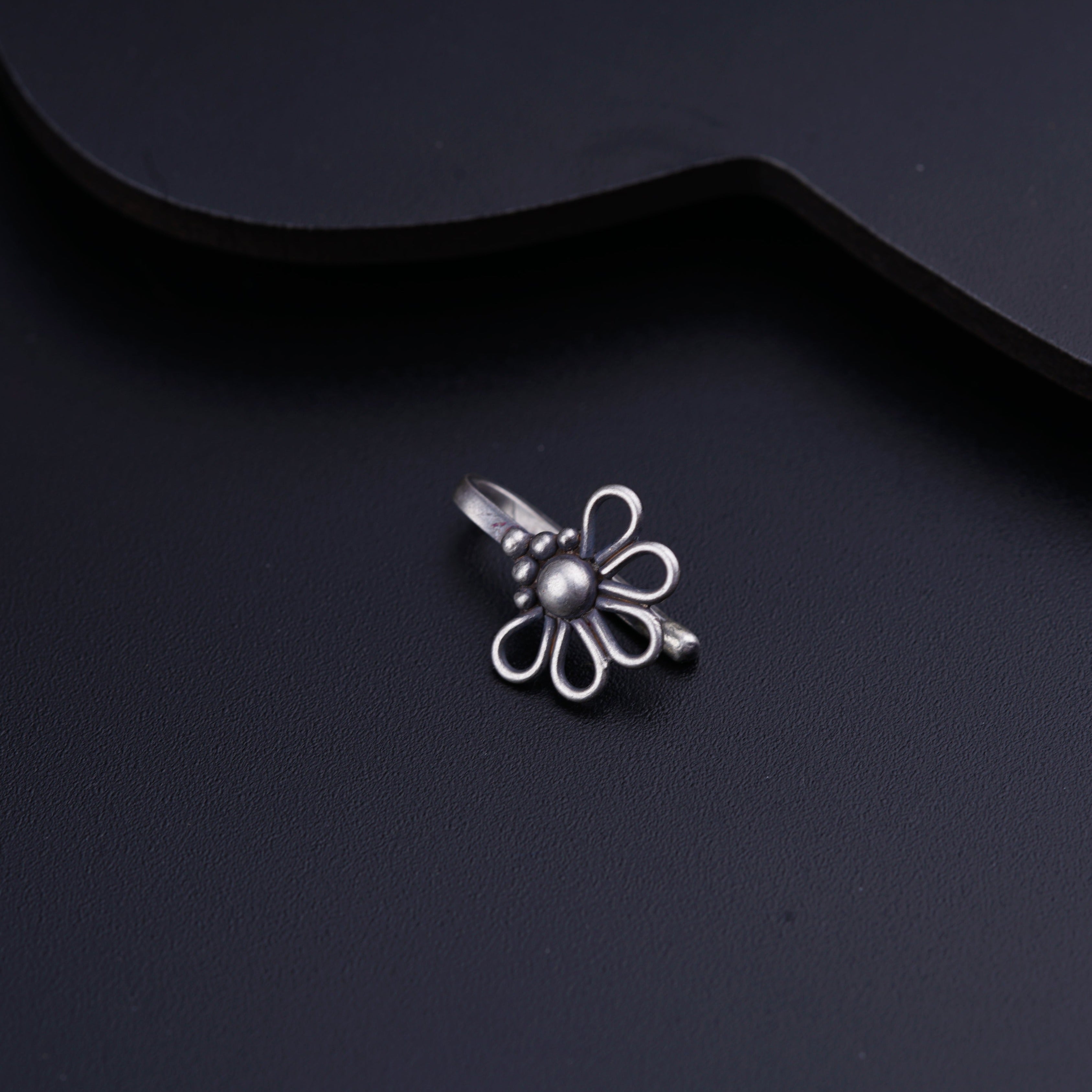 a small silver flower on a black background