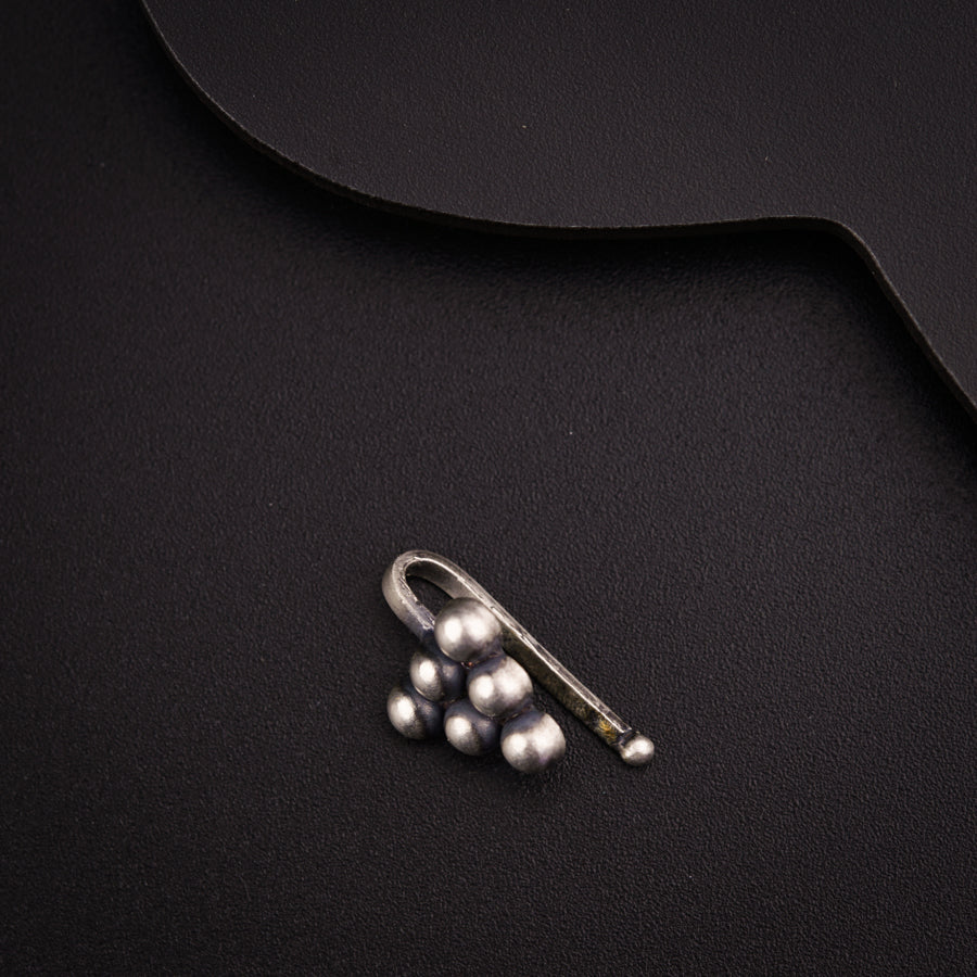 a pair of scissors and some pearls on a black surface