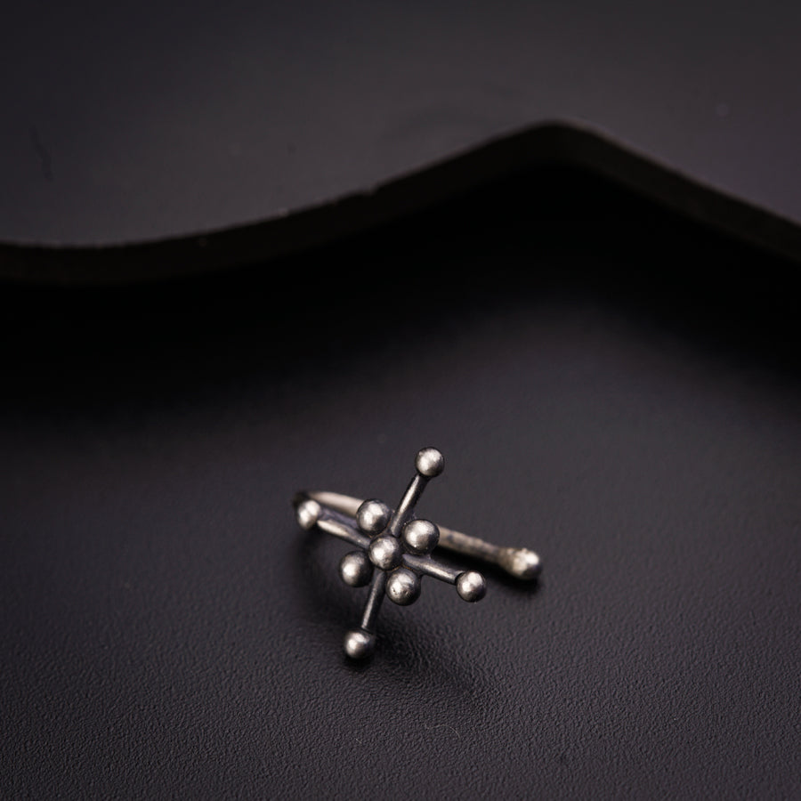 a small silver cross on a black surface