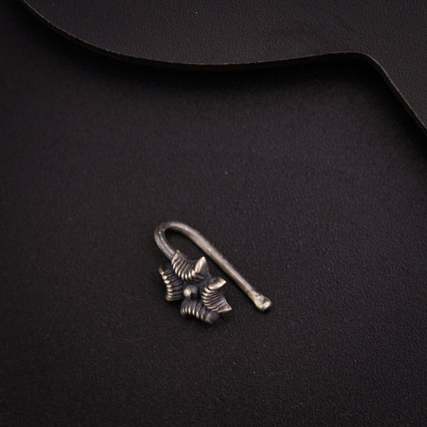 a pair of earrings sitting on top of a black surface