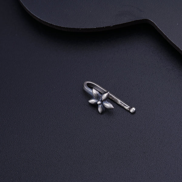 a guitar pick with a small silver flower on it
