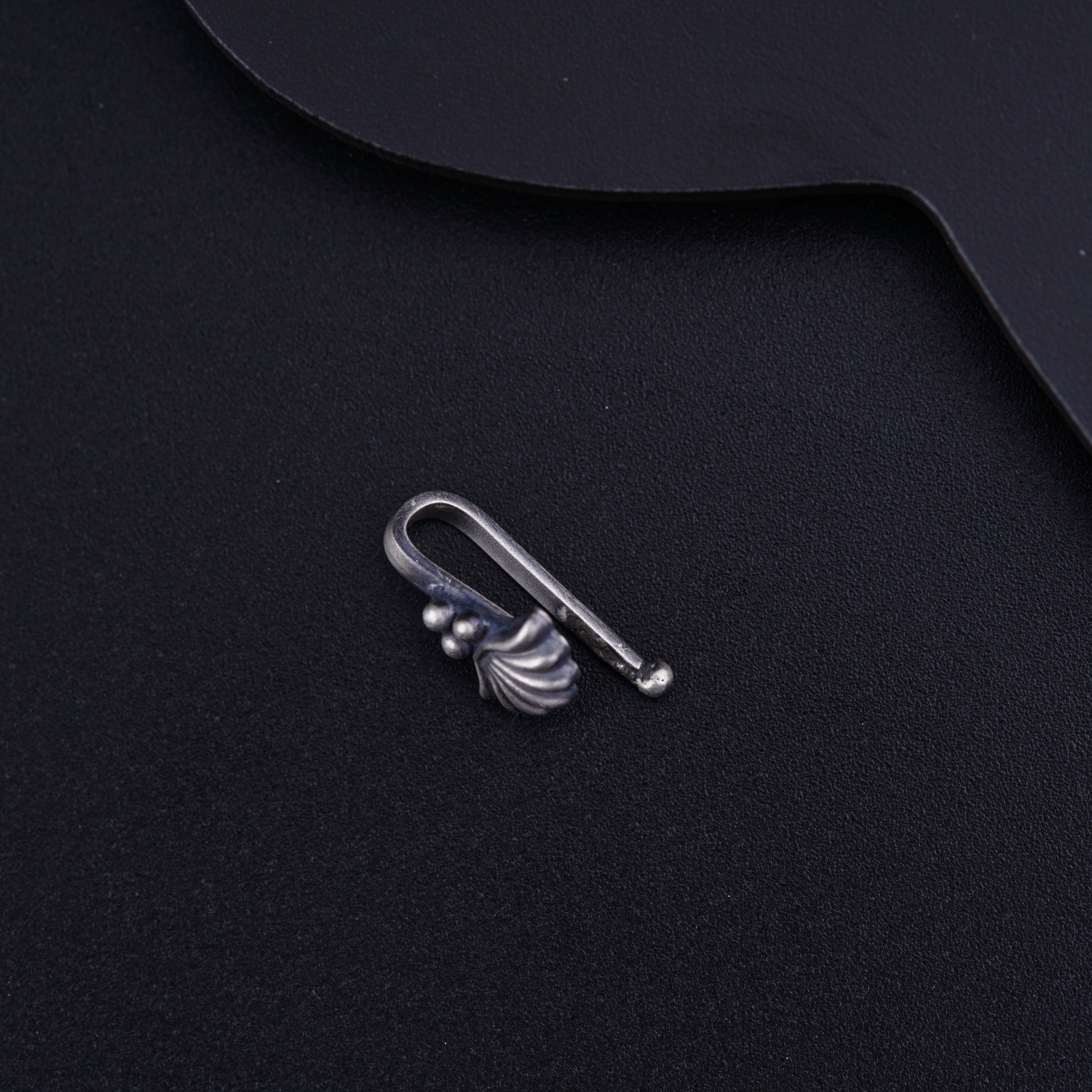 a metal hook on top of a black surface
