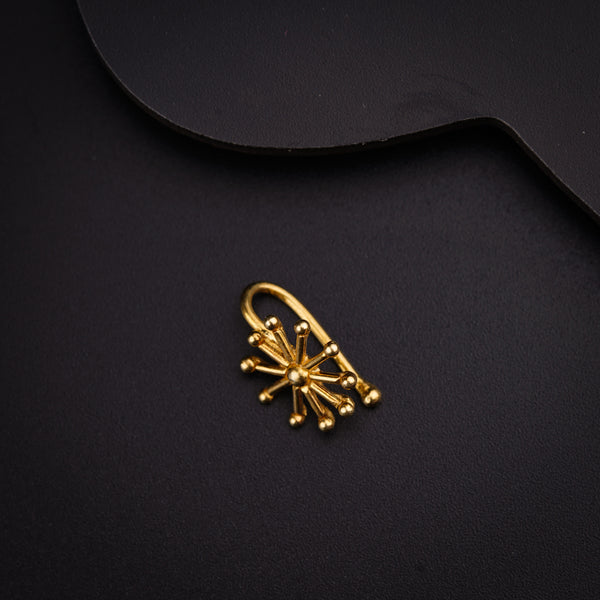 a pair of gold earrings on a black surface