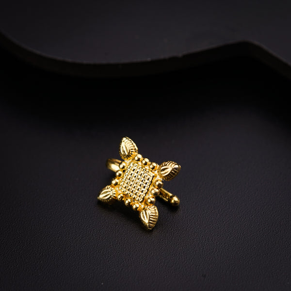 a close up of a gold brooch on a black surface