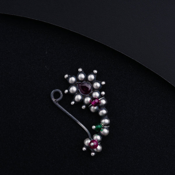 a close up of a brooch on a black surface