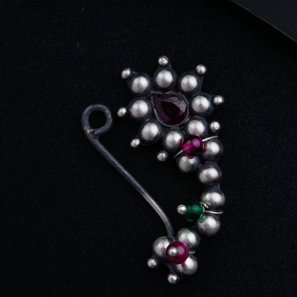 a close up of a brooch on a black surface