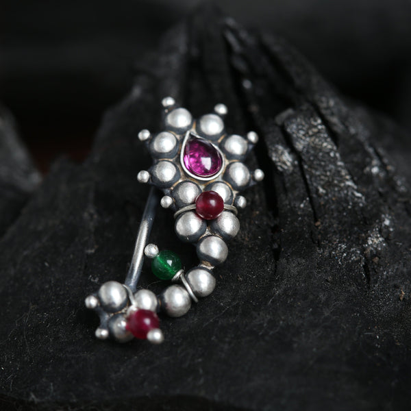 a close up of a brooch on a rock