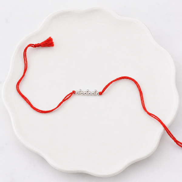 Elegant pearl and silver Rakhi for brother