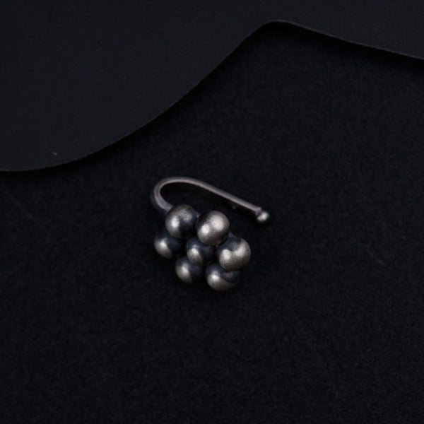 a pair of earrings sitting on top of a black surface