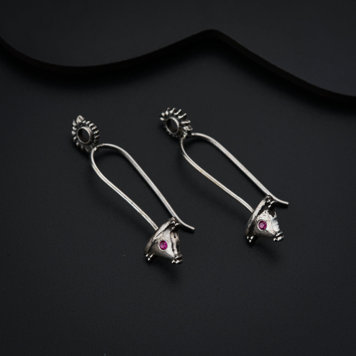 a pair of silver earrings with pink stones