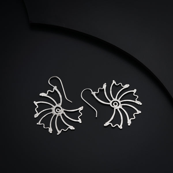 a pair of earrings sitting on top of a black surface