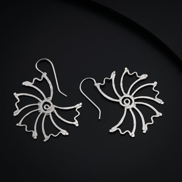 a pair of silver earrings on a black surface