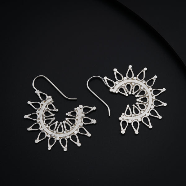 a pair of white earrings sitting on top of a black surface