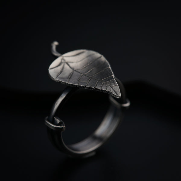 a silver ring with a leaf on it