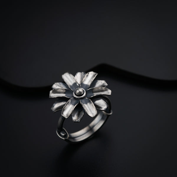 a silver ring with a flower on it